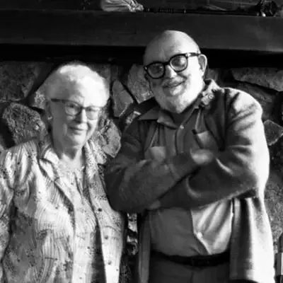 Virginia Best Adams and Ansel Adams standing together in front of a stone fireplace